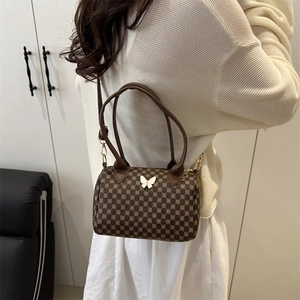 Dettaglio borsa Boston marrone con stampe geometriche e fibbia in metallo a farfalla