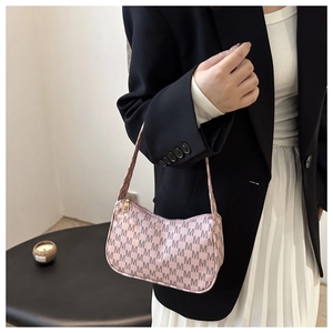 Detail of pink crescent moon shoulder bag featuring repeated grey M monogram patterns