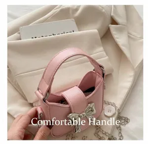 Detailed view of pink leather mini bag featuring a silver bow buckle and chain strap