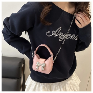Vue détaillée du mini sac bandoulière rose avec nœud métallique argenté et chaîne