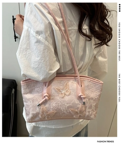 Primer plano del bolso de encaje rosa con bordado de mariposas tridimensionales