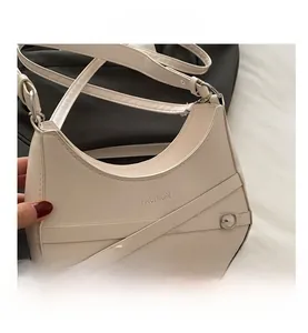 Détail du sac à bandoulière en cuir blanc crème avec sangles et boucle en métal