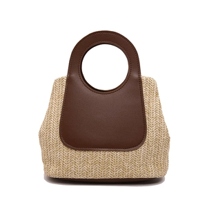 Retro handmade straw tote bag with brown leather paneling and round cutout handles
