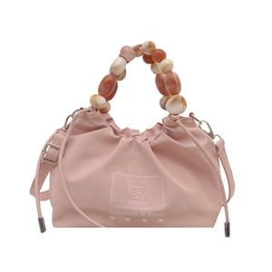 Bolso saco rosa con asa de cuentas y estampado de oso en un estilo moderno y minimalista
