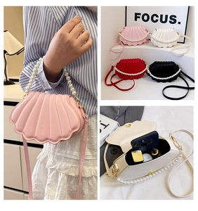 Detail of shell-shaped crossbody bag with pearl handle and multiple color options