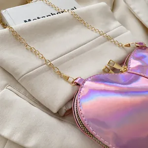 Detailed macro of holographic purple heart bag with dual zippers and gold chain strap
