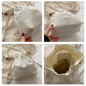 Close-up of white floral lace bucket bag showing interior space for phone and wallet