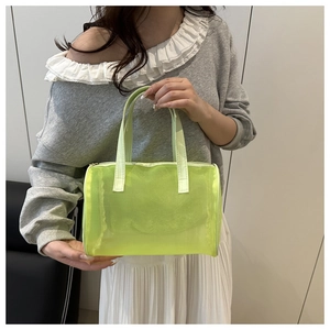 Dettaglio della borsa da viaggio verde neon semitrasparente con doppi manici