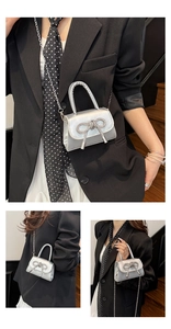 Detalle de mini bolso plateado con lazo de diamantes y correa de cadena metálica