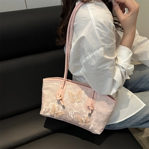 Bolso tote de encaje rosa con bordado de mariposa 3D llevado por una modelo