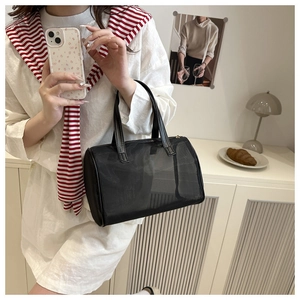 Close-up of black mesh boston handbag with leather handles and top zipper detail