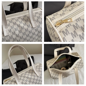 Detail view of large tote bag with M-letter print, golden hardware and spacious interior