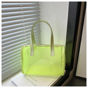 Detailopname van de neon groene mesh toilettas met wit handvat op een wit boek