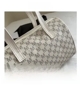 Close-up of cream Boston bag with grey M monogram pattern and lychee grain leather texture