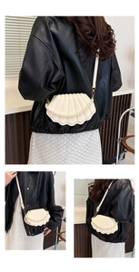Detail showing white shell crossbody bag with pearl handle and textured leather finish