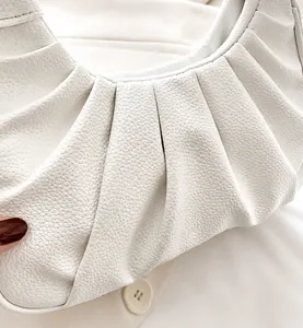 Détail du sac à bandoulière blanc froncé en cuir grainé avec bouton décoratif