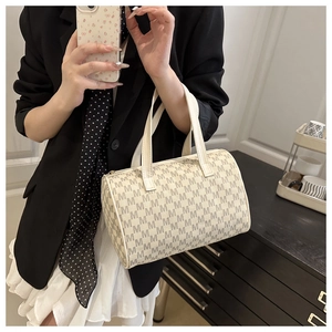 Detail of Boston handbag featuring M-letter monogram print and cream leather handles
