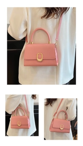 Detail of pink PU leather handbag featuring a gold oval clasp and adjustable strap