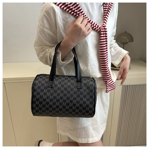 Detailed view of Boston handbag featuring white M monogram pattern and black leather handles