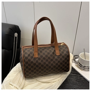 Détail du sac cylindre vintage avec motif M marron et fermeture éclair dorée