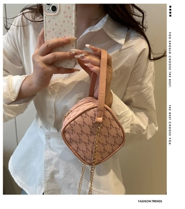 Détail du sac à main rose en PU avec motif M marron et attache de bandoulière dorée