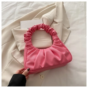 Détail du sac hobo plissé rose en cuir PU grainé posé sur un blazer beige élégant