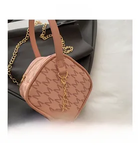 Détail du sac cylindre rose à monogramme avec chaîne dorée et fermeture éclair