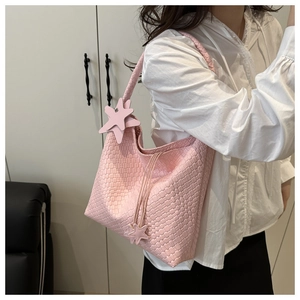 Dettaglio della trama intrecciata rosa su borsa hobo grande con ciondolo a stella