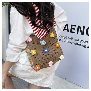 Detail of handmade crochet shoulder bag with colorful 3D floral patterns and hollow knit