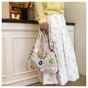 Détail d'un sac cabas au crochet fait main avec des motifs floraux colorés en relief