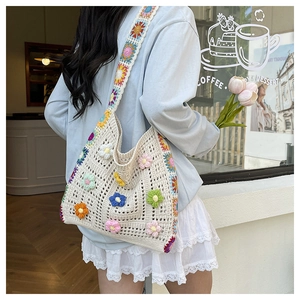 Detail der floralen Häkeltasche mit bunten 3D-Blüten und gewebtem Schultergurt