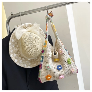 Details der handgehäkelten Tasche mit 3D-Blumen und Strohhut mit Perlenverzierung