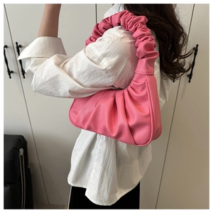 Détail du sac à bandoulière rose plissé montrant le cuir grainé et le design hobo nuage