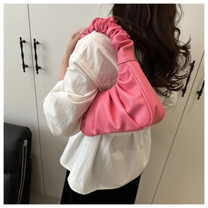 Détail du sac à bandoulière en similicuir plissé rose avec texture litchi et poignée