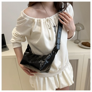 Detail of black glossy leather bag with metal eyelet strap and modern minimalist design