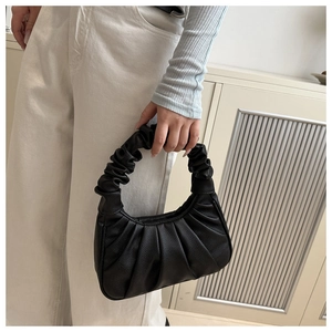 Détail d'un sac nuage noir avec poignée froncée et texture en similicuir grainé chic