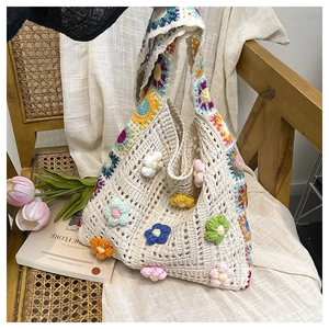 Détail d'un sac à bandoulière au crochet fait main avec motifs floraux 3D et maille