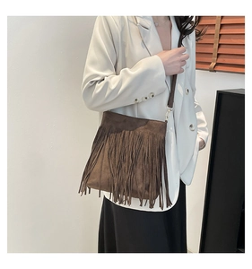 Vue détaillée du sac à bandoulière en daim marron avec de longues franges et métal doré
