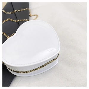 Detailansicht der weißen herzförmigen Mini-Tasche mit goldenem Reißverschluss und Metallkette