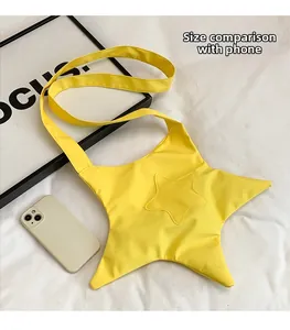 Size comparison of a yellow star-shaped nylon crossbody bag next to a mobile phone