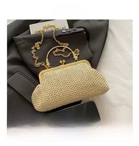 Detail of beige straw shell bag with gold handle, chain strap, and phone for scale