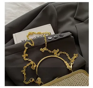 Detail of woven shell bag featuring gold metal handle and detachable chain strap link