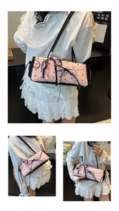 Dettaglio del tessuto jacquard rosa con motivi a fiocco nero e nastro intrecciato sulla borsa