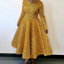 Close-up of sparkling gold sequins and premium texture on a pleated festive gown