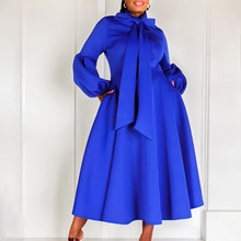 Detail of elegant royal blue midi dress featuring large bow neck and puff sleeves