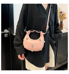 Détail du sac demi-lune rose avec clous métalliques argentés et bandoulière réglable