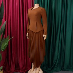 Close-up of caramel long-sleeve dress with structured ruffles and pleated irregular hemline