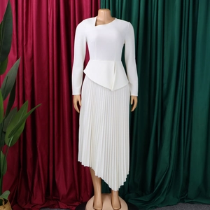 Detail of white asymmetric dress with pleated skirt and ruffled peplum waist detail