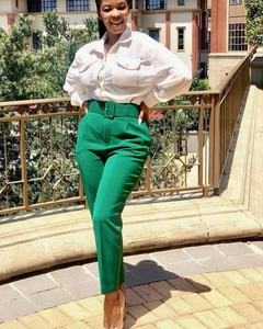 Detail of high-waist green trousers with belt and white button-down cargo shirt