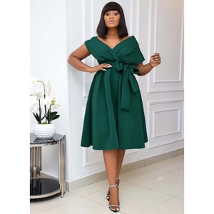 Detail of dark green evening dress featuring an elegant waist bow and deep V-neckline